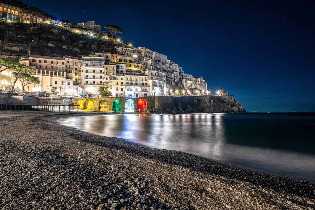 Amalfi. Il Comune illumina col tricolore le arcate della Marina Grande. La speranza da uno dei paesaggi simbolo d