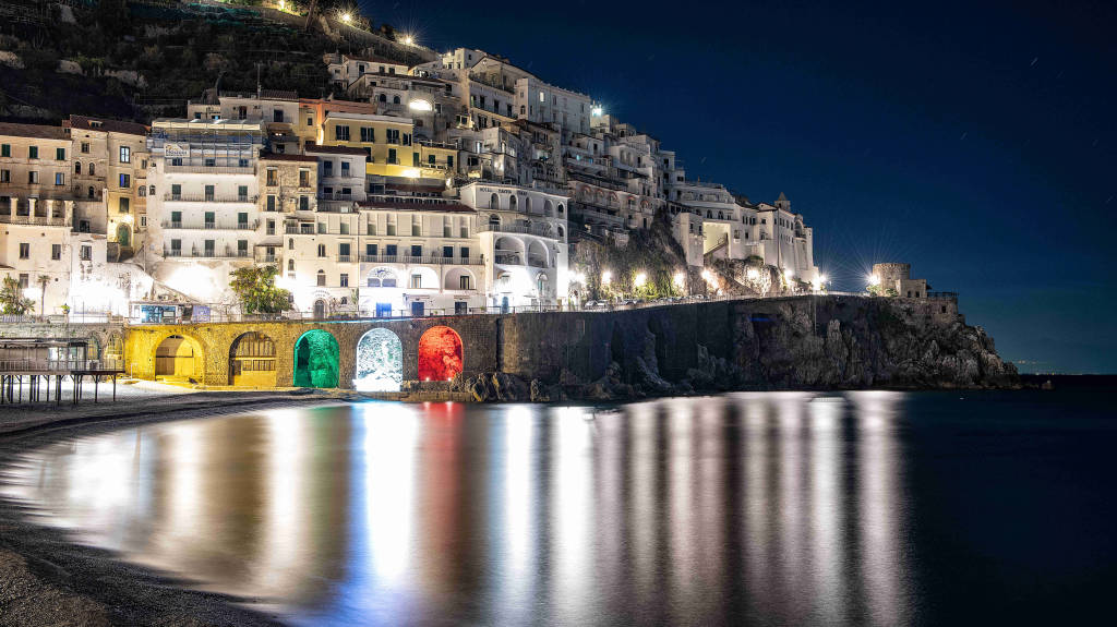 Amalfi. Il Comune illumina col tricolore le arcate della Marina Grande. La speranza da uno dei paesaggi simbolo d